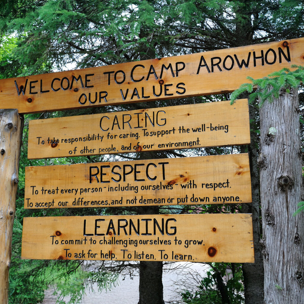 Wooden Sign at Camp Arowhon with their values written out - caring, respect and learning