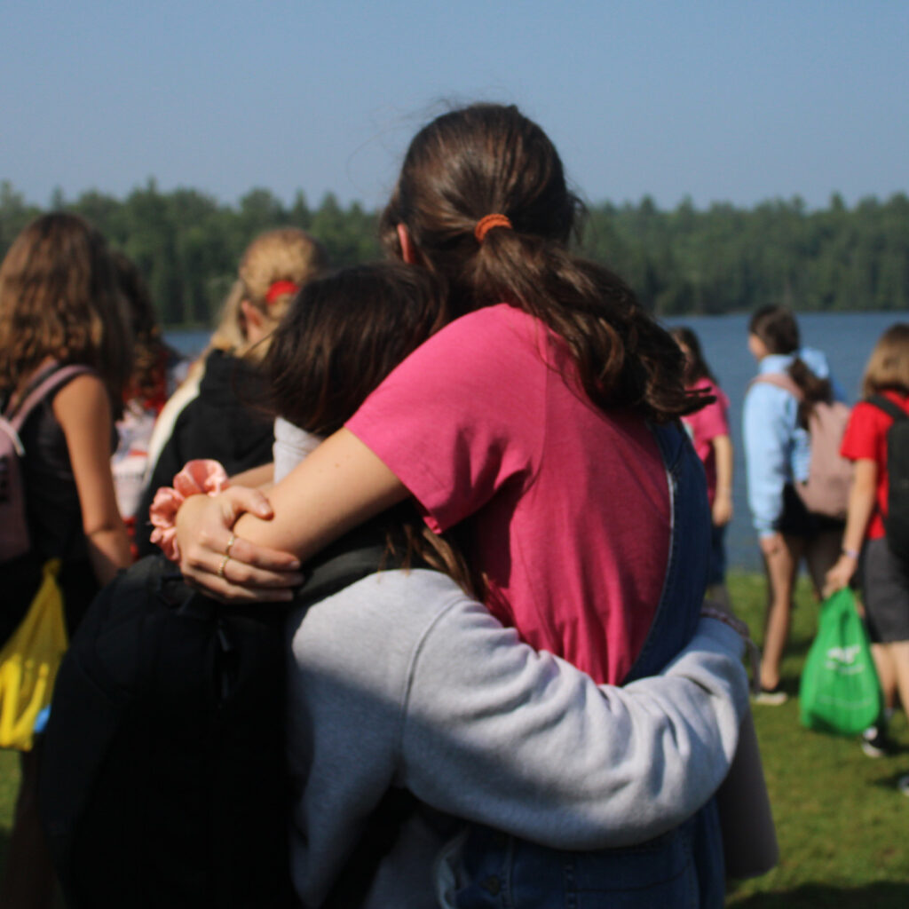 two children hugging outside at camp arowhon