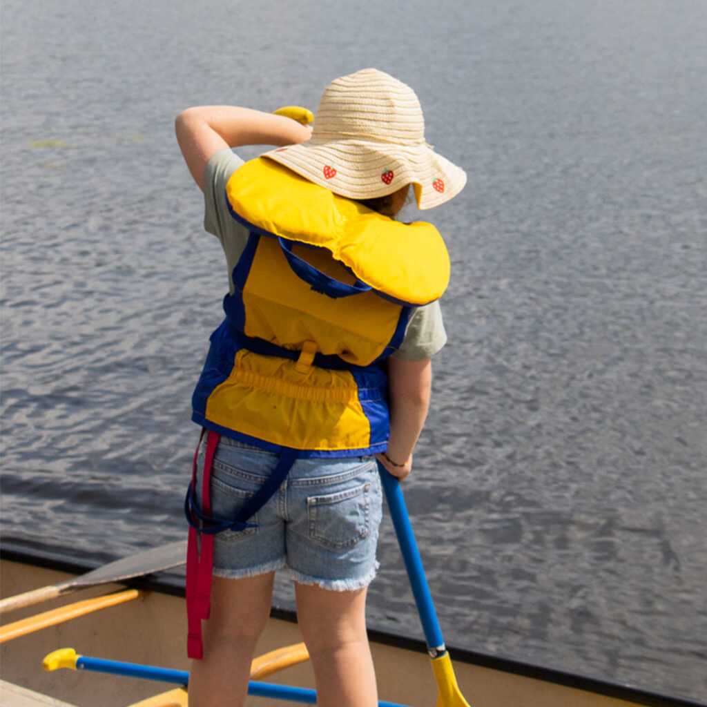 camper wearing hat paddling
