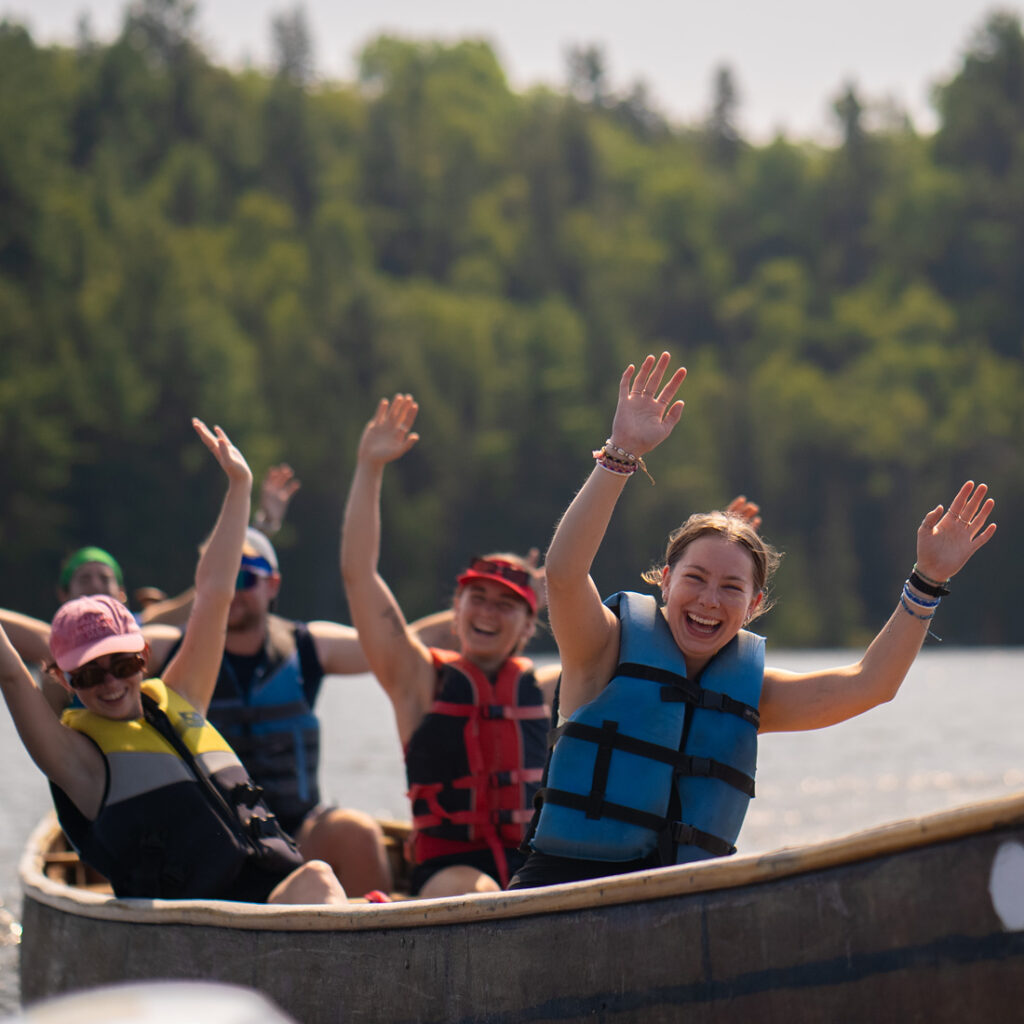 counsellor and team in canoe on the water at camp arowhon