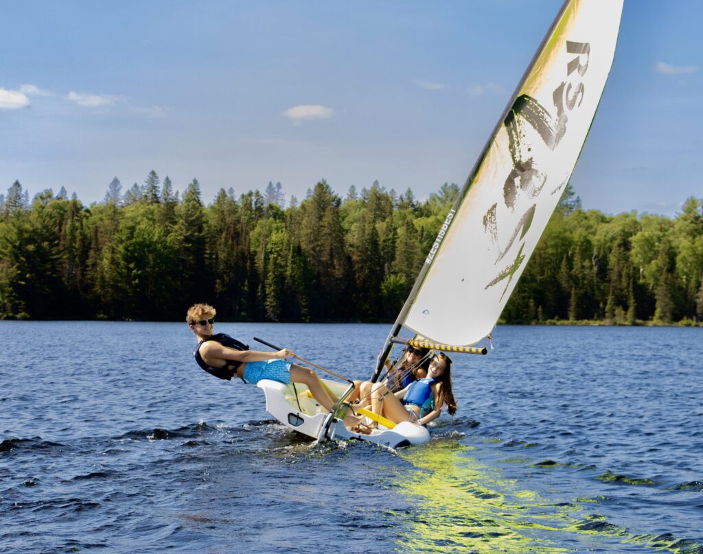 Kids learning to sail at a screen-free overnight summer camp in Algonquin Park Ontario at Camp Arowhon